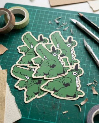 Sticker vinil matte Cocodrilo Tonto 7x8 cm con gorrita y lengüita, contorno recortado, diseño original ChimChim México