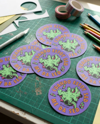 Sticker vinil matte circular Drunkzilla 6.5cm, lagarto verde patas arriba con botellas y texto cuando estoy sad me da sed, fondo lila ChimChim México