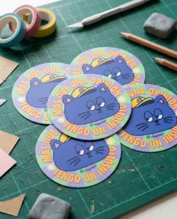Sticker vinil matte circular Más Que una Opinión 6.5cm, gato azul con gorrita amarilla y frase más que una opinión tengo un insulto, ChimChim México