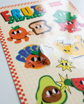 Lámina de stickers Frutibanda ChimChim sostenida en mano, vinil brilloso die cut hecho en México